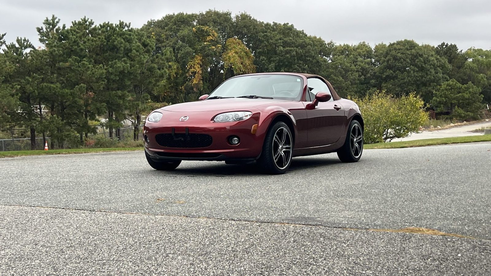 Red 2008 Mazda MX-5 Miata Grand Touring parked in front of a green and white building