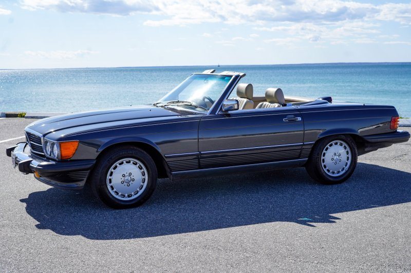 Dark blue Mercedes-Benz 560 SL convertible beside the ocean